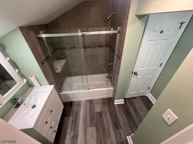 a view of an empty room with wooden floor and stairs