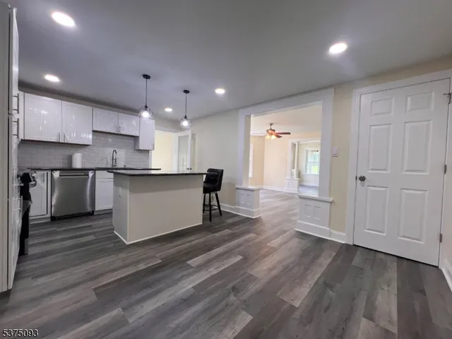 a large kitchen with stainless steel appliances granite countertop a large stove a sink dishwasher and a refrigerator with wooden floor