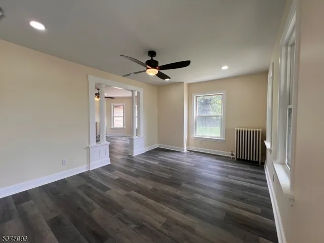 a view of a livingroom with wooden floor and a ceiling fan