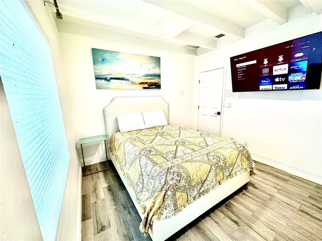 a bedroom with a bed and a flat screen tv