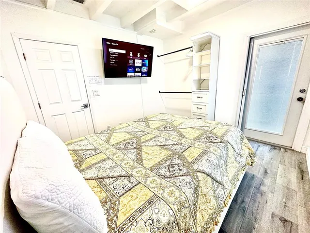 a bedroom with a bed and a flat screen tv
