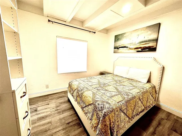 a bedroom with a bed and a painting on the wall