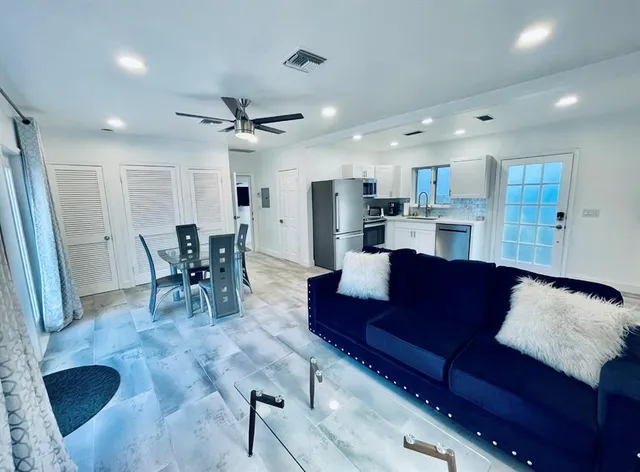 a living room with furniture and kitchen view