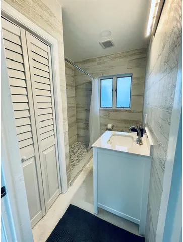 a bathroom with a sink and mirror with bathtub