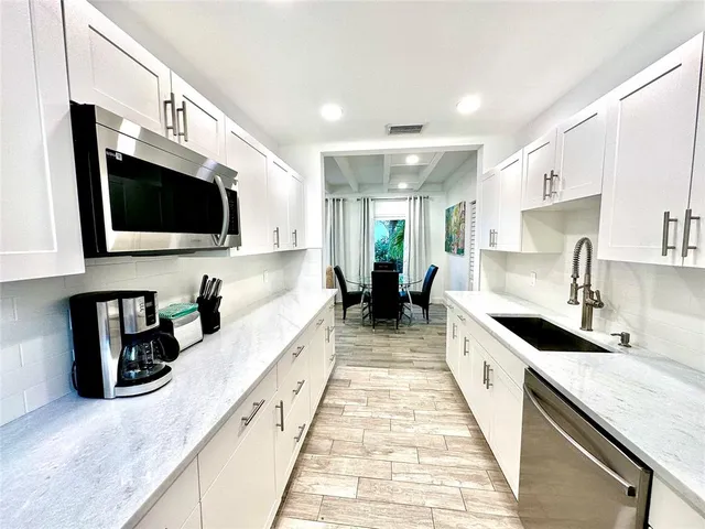 a large white kitchen with a large window