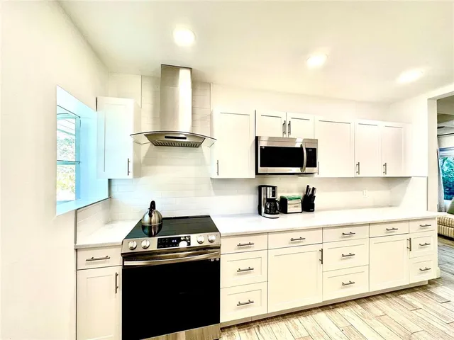 a kitchen with white cabinets and appliances