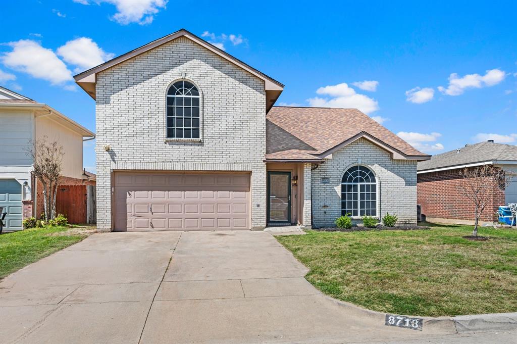 8713 Granite Path Fort Worth, TX 76244 - Photo 1 of 40 Charming two-story brick elevation with arched windows, mature landscaping, and a spacious two-car garage.