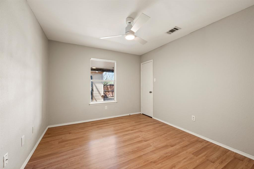 8713 Granite Path Fort Worth, TX 76244 - Photo 21 of 40 Bright secondary bedroom with wood-look flooring, neutral tones, ceiling fan, and natural light.