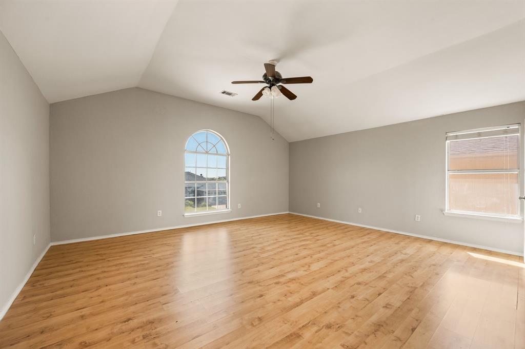 8713 Granite Path Fort Worth, TX 76244 - Photo 29 of 40 Huge bedroom retreat with vaulted ceilings, arched window, and generous floor space.