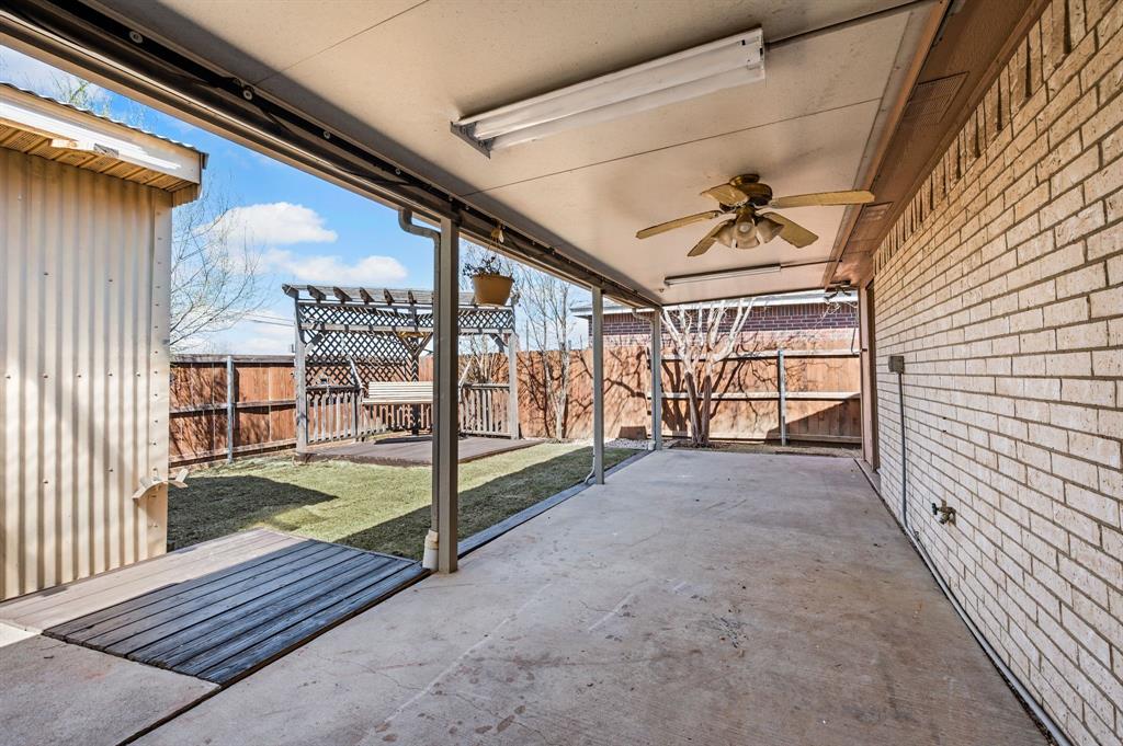 8713 Granite Path Fort Worth, TX 76244 - Photo 35 of 40 Extended covered patio overlooking backyard and detached storage building.