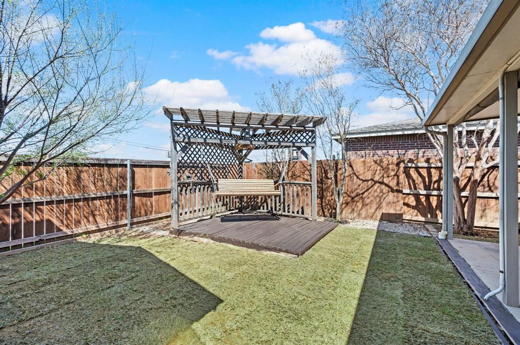 8713 Granite Path Fort Worth, TX 76244 - Photo 37 of 40 Backyard pergola deck with swing seating and shaded outdoor entertaining space.