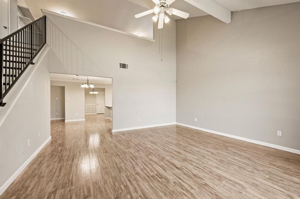 8713 Granite Path Fort Worth, TX 76244 - Photo 5 of 40 Expansive living room featuring soaring ceilings, abundant natural light, and durable wood-look flooring.