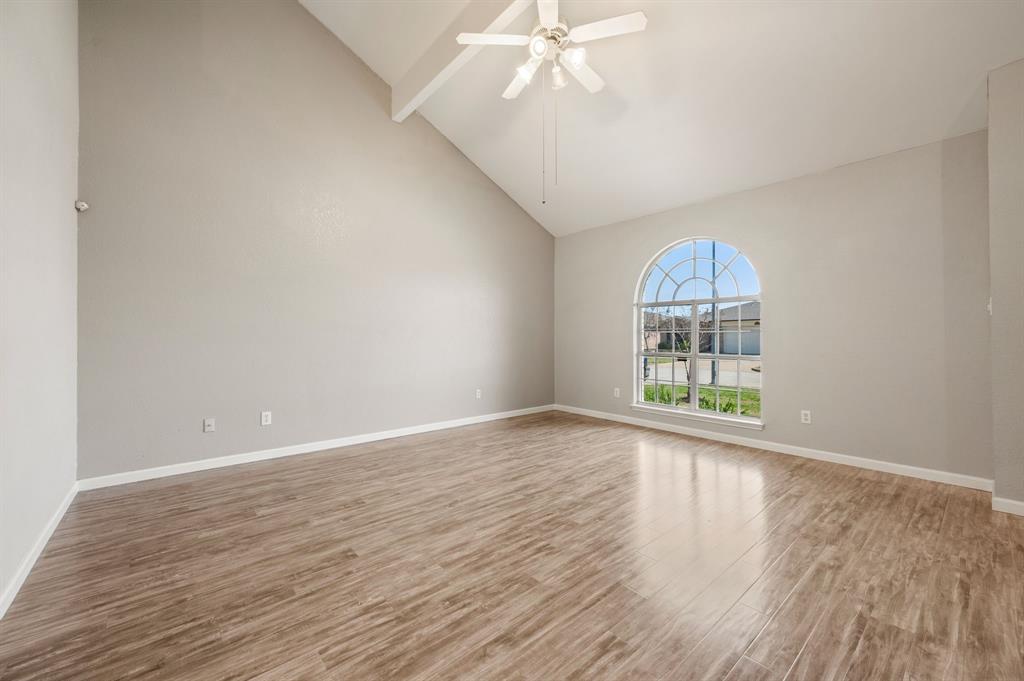 8713 Granite Path Fort Worth, TX 76244 - Photo 6 of 40 Alternate view of the living area showcasing vaulted ceilings and large arched window for natural light.