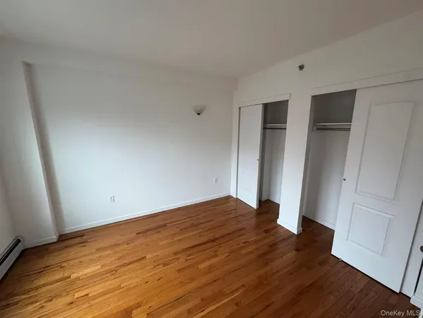 an empty room with wooden floor and closet