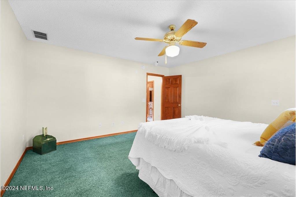123 Unicorn Road St. Augustine, FL 32086 - Photo 11 of 51 a bedroom with a bed and a chandelier