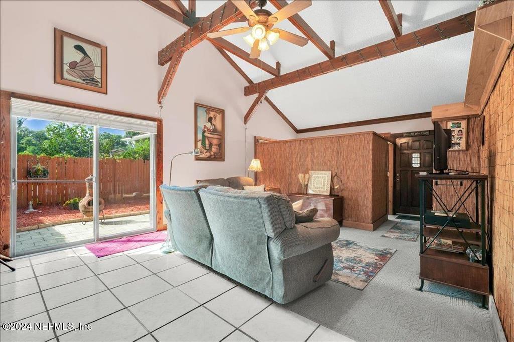 123 Unicorn Road St. Augustine, FL 32086 - Photo 22 of 51 a living room with furniture a flat screen tv and a floor to ceiling window