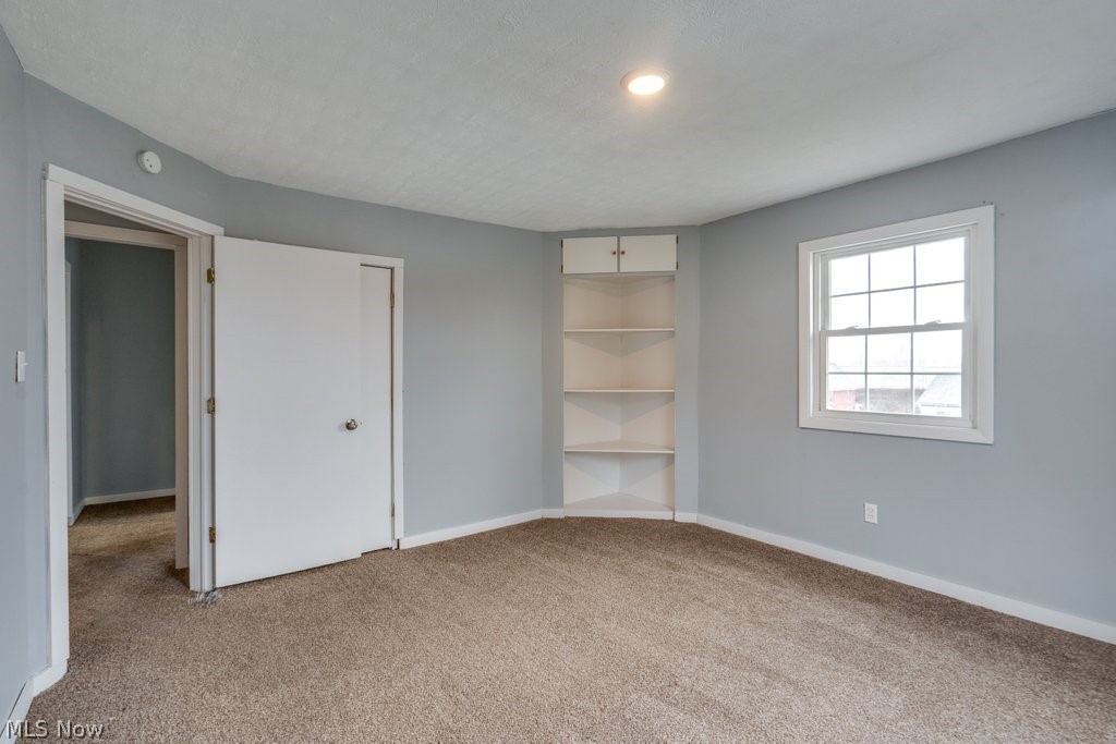 1607 9th Street Southwest Canton, OH 44706 - Photo 26 of 41 Carpeted room featuring a double-hung window, recessed lighting, and built-in corner shelving with upper cabinetry