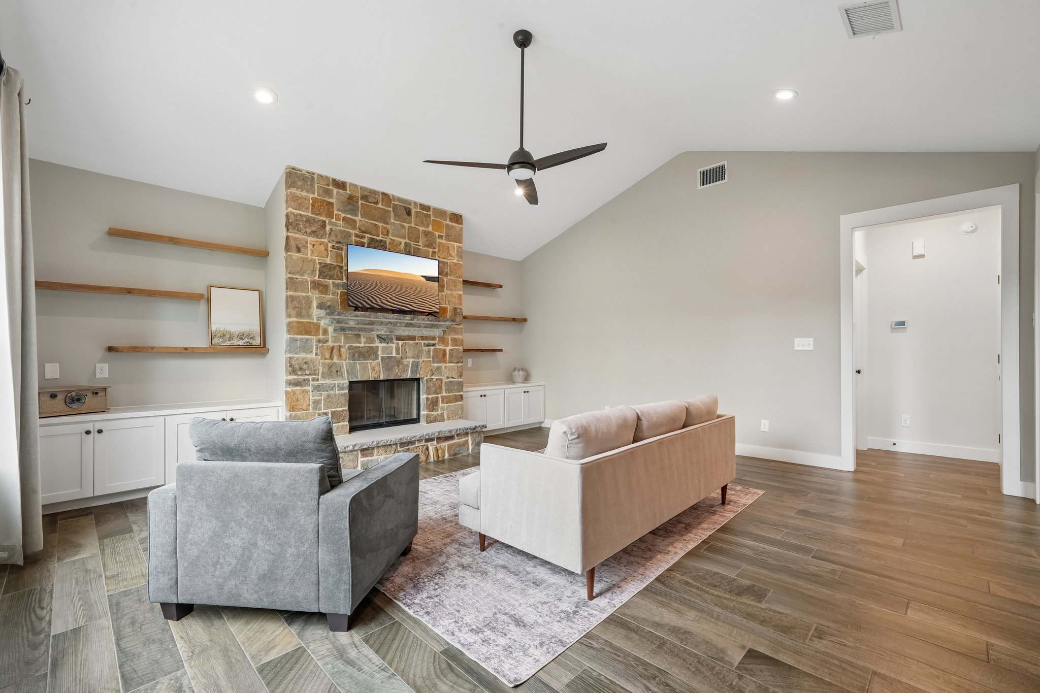 190 Magnolia Meadow Spring Branch, TX 78070 - Photo 4 of 29 A striking stone fireplace anchors this living space, offering warmth and style under vaulted ceilings.