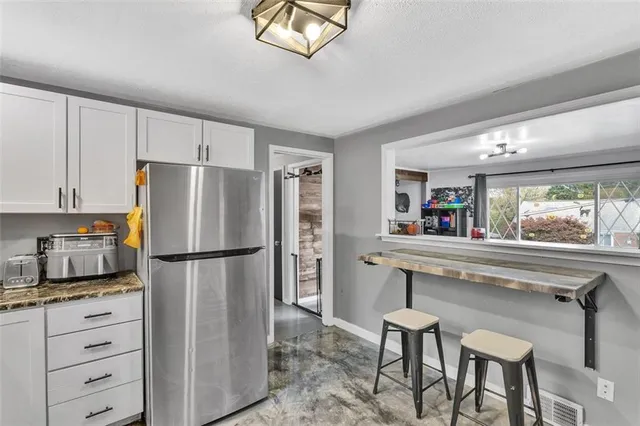 a kitchen with appliances a refrigerator and cabinets