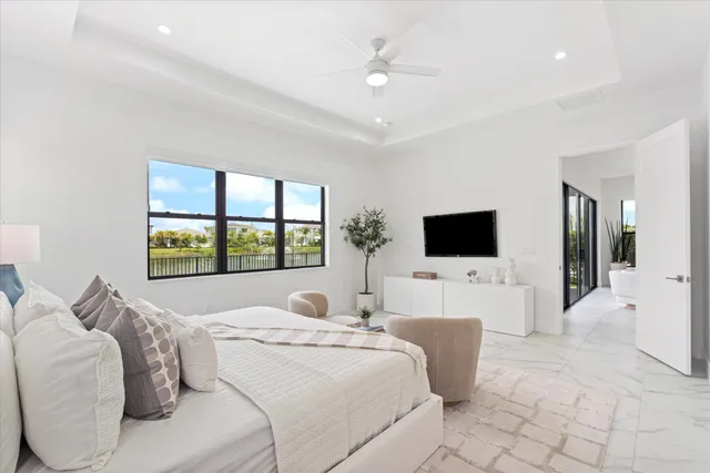 a bed room with a bed a television and a large window