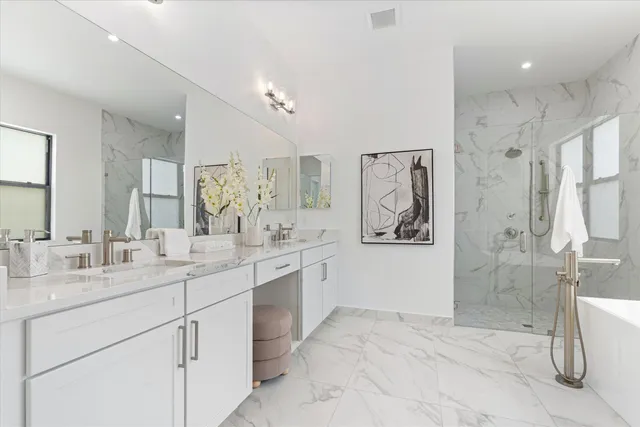 a spacious bathroom with a shower sink double vanity and mirror