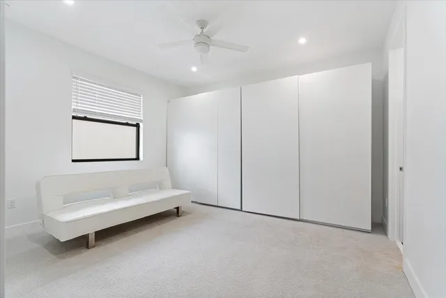 a spacious bedroom with a bed and a ceiling fan