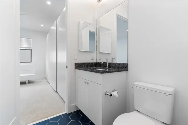 a bathroom with a granite countertop sink and a mirror
