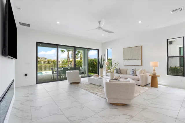 a living room with furniture large window and flat screen tv