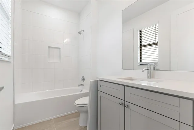 a bathroom with a granite countertop sink a toilet and shower