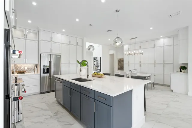 a kitchen with a sink refrigerator and cabinets