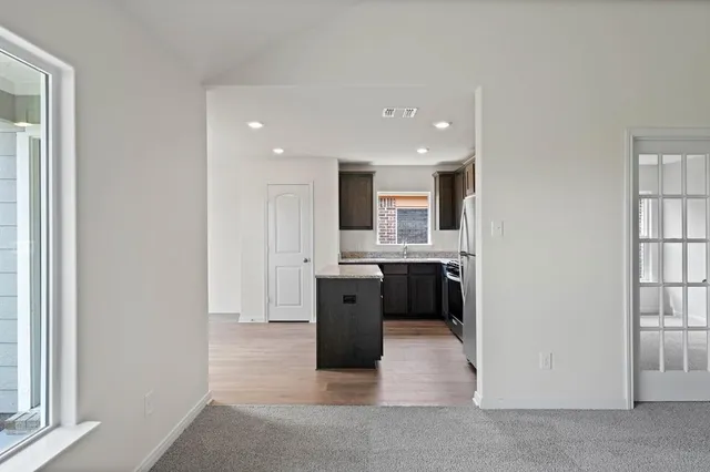 a view of a kitchen with a sink and dishwasher a refrigerator with wooden floor