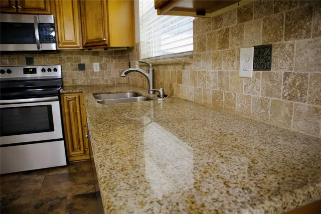 a bathroom with a granite countertop sink and a washing machine