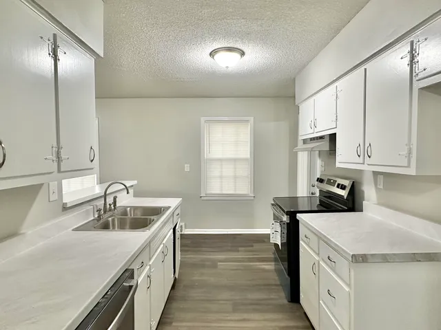 a kitchen with a sink stove and cabinets