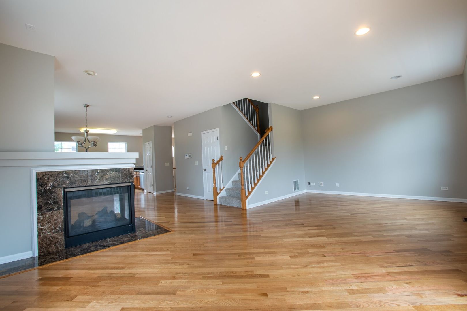 4125 Bethlehem Road Aurora, IL 60504 - Photo 6 of 19 a view of an empty room with wooden floor a fireplace