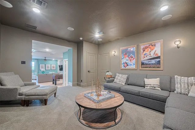 a living room with furniture kitchen view and a chandelier