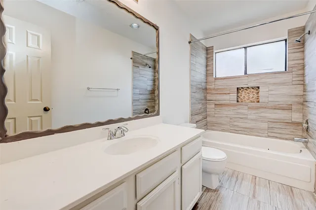 a bathroom with a sink a toilet a tub and shower