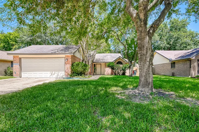 a view of a house with backyard and a tree