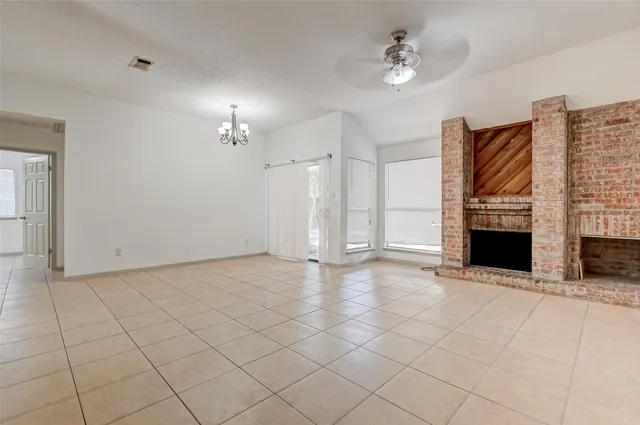 a view of an empty room with a fireplace and a window