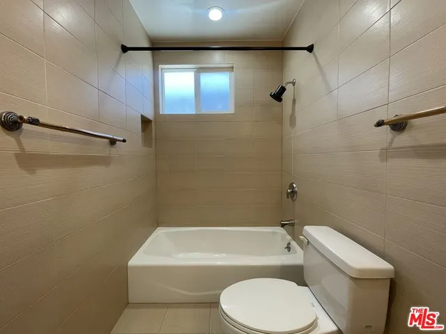 a white toilet and tub sitting next to a bathroom sink