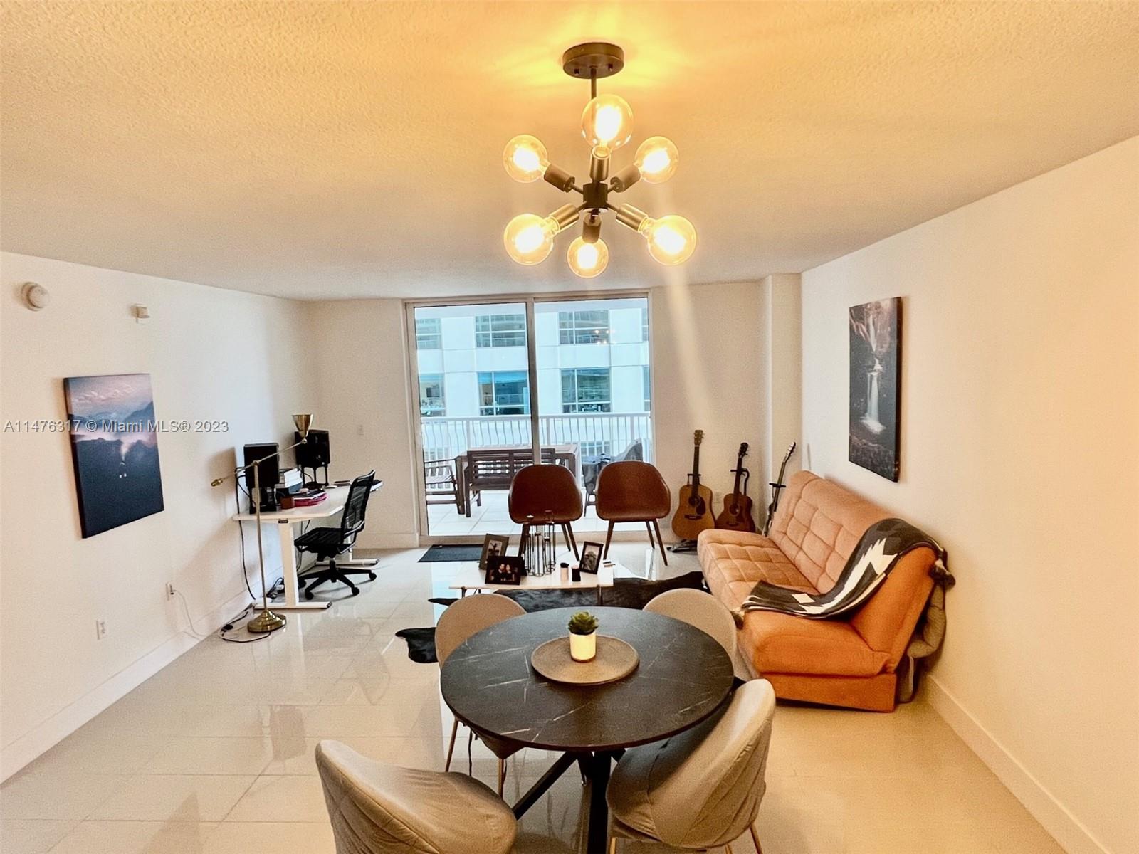 a living room with furniture a chandelier and a dining table