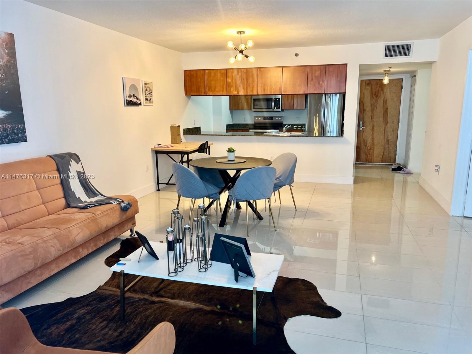 1200 Brickell Bay Drive, Unit 2008 Miami, FL 33131 - Photo 2 of 37 a living room with stainless steel appliances kitchen island granite countertop furniture and a kitchen view