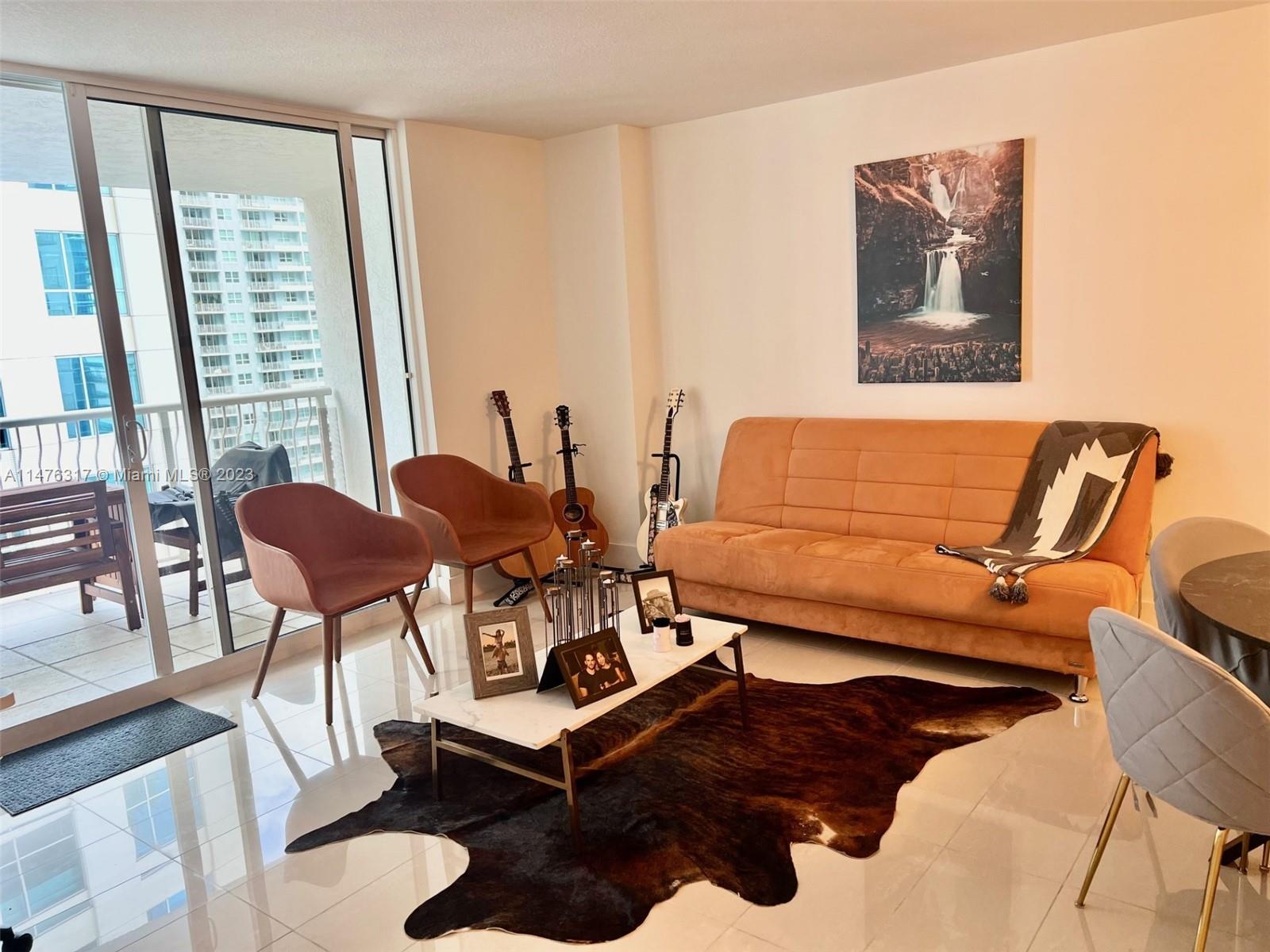 1200 Brickell Bay Drive, Unit 2008 Miami, FL 33131 - Photo 4 of 37 a living room with furniture and a window