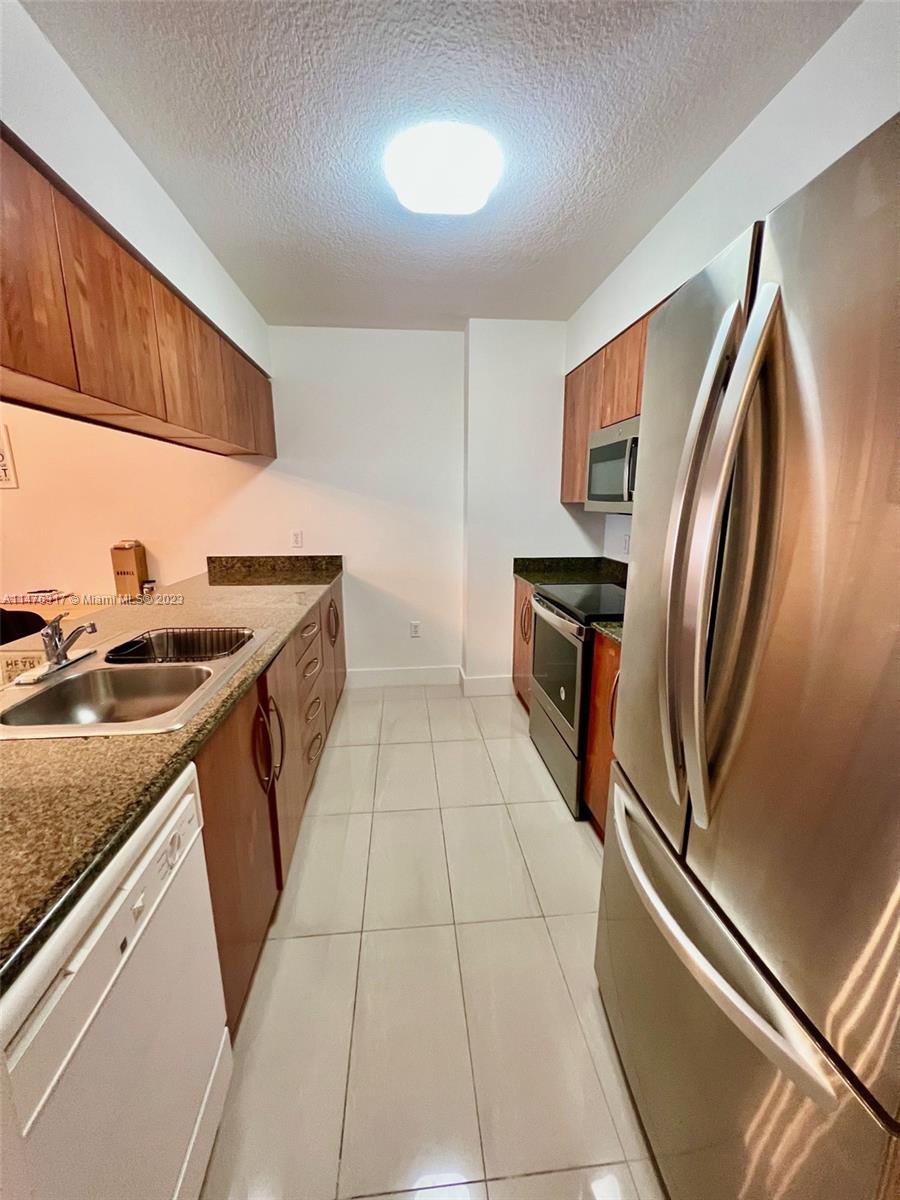 1200 Brickell Bay Drive, Unit 2008 Miami, FL 33131 - Photo 6 of 37 a kitchen with a sink stove and refrigerator