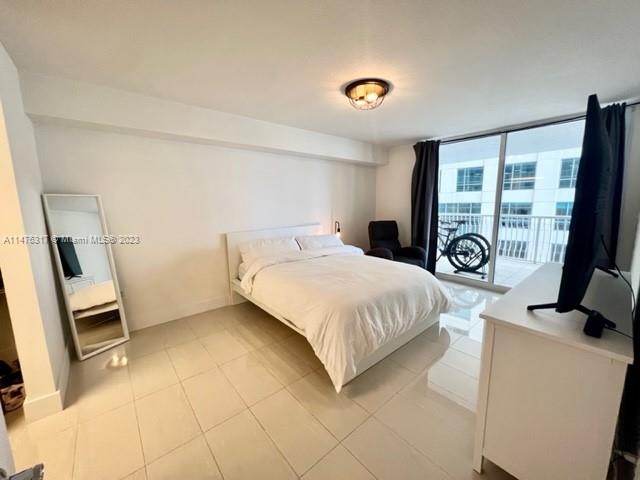 1200 Brickell Bay Drive, Unit 2008 Miami, FL 33131 - Photo 9 of 37 a bedroom with a bed and a large window