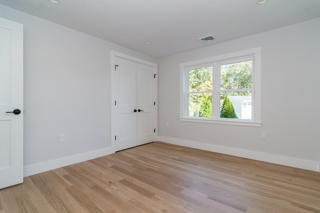 28 Perry Drive Needham, MA 02492 - Photo 22 of 35 a view of an empty room with wooden floor and a window
