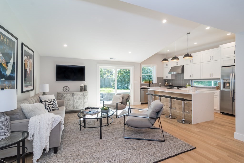 28 Perry Drive Needham, MA 02492 - Photo 5 of 35 a living room with furniture a flat screen tv and kitchen view