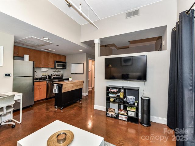 a kitchen with stainless steel appliances granite countertop a refrigerator a stove a sink and a microwave