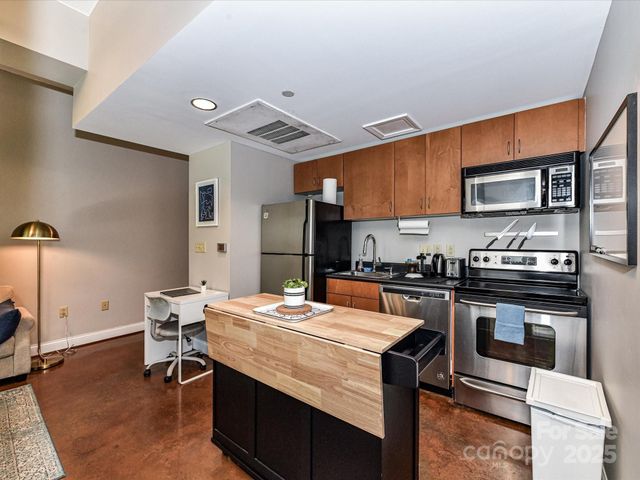 a kitchen with stainless steel appliances granite countertop a sink stove and microwave