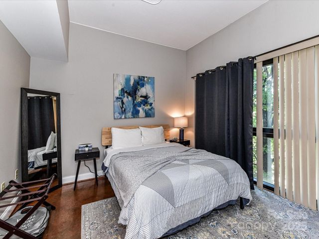 a bedroom with a bed and a lamp on dresser