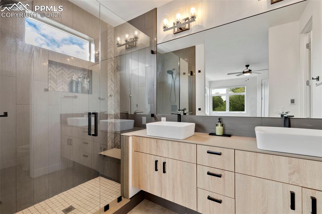 50 Sommerlyn Road Colorado Springs, CO 80906 - Photo 22 of 39 a bathroom with a double vanity sink a mirror and a shower